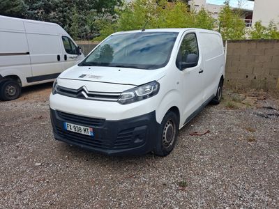 une camionnette blanche garée dans un parking à côté d'une camionnette blanche