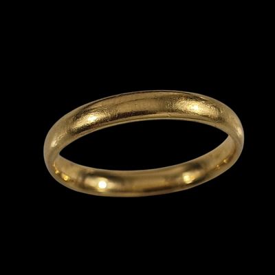 gros plan d'une bague en or sur fond noir