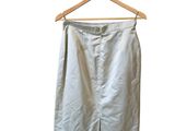 a white skirt hanging on a wooden hanger on a white wall