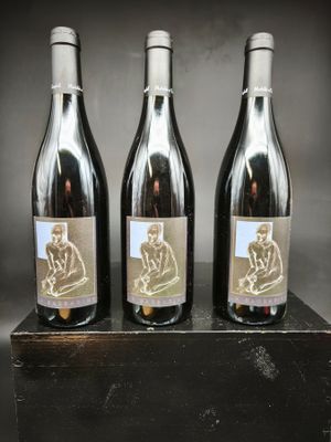 trois bouteilles de vin posées sur un bloc de bois