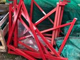 un tas d'objets métalliques rouges posés par terre à côté d'une bâche verte