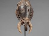 a wooden mask with horns on a stand