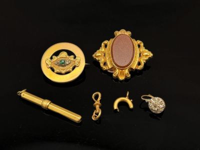quelques bijoux en or, notamment un stylo, une bague et une broche