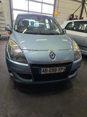 La voiture bleue est garée dans le garage, à côté d'autres voitures.