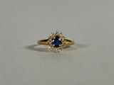 a yellow gold ring with a blue sapphire and white diamonds