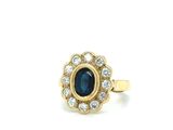 a close up of a gold ring with a blue stone surrounded by diamonds