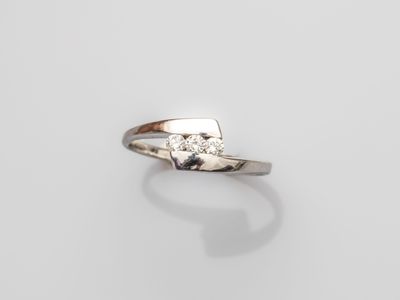 a close up of a diamond ring on a white surface