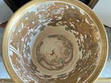 an old bowl sitting on top of a rug next to a mirror