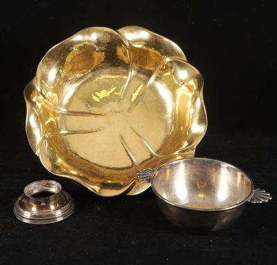 un bol en argent et une cuillère en argent posés sur une surface noire