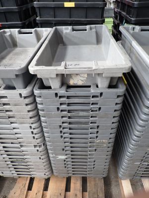 plusieurs conteneurs en plastique empilés les uns sur les autres sur une palette