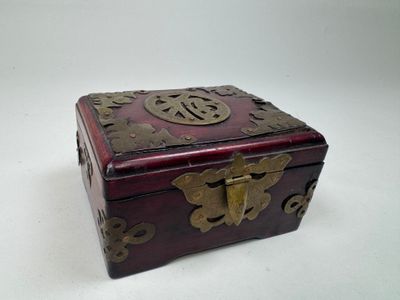 une petite boîte en bois ornée de décorations métalliques