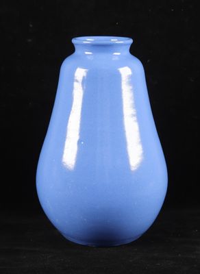 un vase bleu posé sur une surface noire