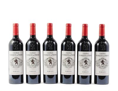 quatre bouteilles de vin rouge sont alignées sur une surface blanche