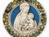 a close up of a plate with a statue of a woman holding a baby