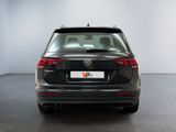 the back of a black volkswagen vw parked in a white room