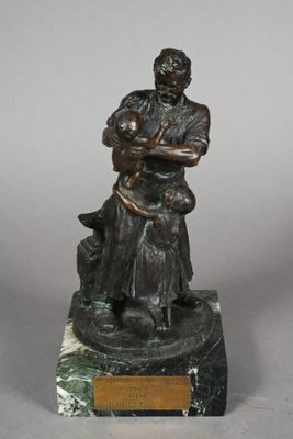 statue en bronze représentant un homme tenant un bébé et un chien, posée sur un socle en marbre