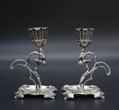 une paire de bougeoirs en argent ornés de fleurs et de feuilles