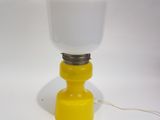 une image représentant une lampe jaune et blanche posée sur une surface blanche