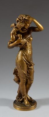 statue en bronze représentant une femme tenant un bébé dans ses bras, posée sur un socle