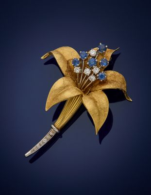an image of a gold and blue flower broochle on a blue background