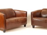 paire de fauteuils en cuir marron avec des pieds et des accoudoirs en bois