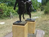 une statue représentant un garçon et une fille debout sur un socle