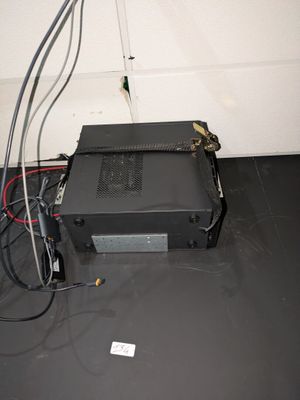 une boîte noire à laquelle sont reliés des fils, dans une pièce