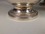 a silver bowl sitting on top of a white table