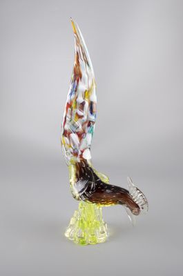 une photo d'une sculpture en verre représentant un oiseau posée sur un socle