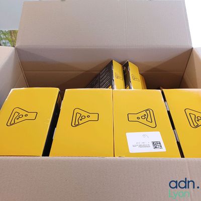 une boîte en carton remplie de boîtes jaunes sur lesquelles est collé un autocollant