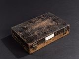 an old suitcase that is sitting on a black surface
