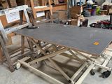 a table that is sitting on a dolly in a garage