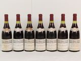 six bouteilles de vin sont alignées sur une table