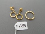 three gold rings and a price tag on a gray surface