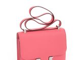 a small pink bag with a metal handle on a white background
