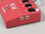 an image of a red guitar pedal sitting on top of a table