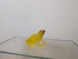 a yellow frog sitting on top of a glass table
