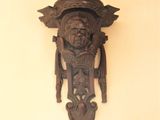 a wooden clock on the wall with a bird on it