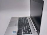 a silver laptop computer sitting on a white surface