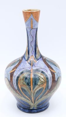 a blue and brown vase on a white surface