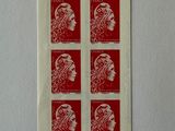 a close up of a piece of red paper with a woman ' s head on it