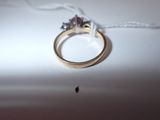 a gold ring with a pink and white diamond on it