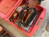 un homme tenant un outil dans une boîte rouge