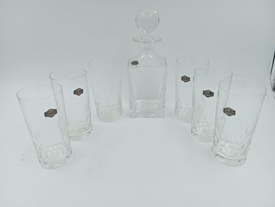 six verres et une carafe posés sur une table