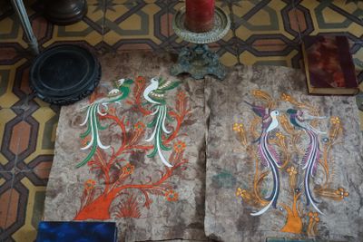 deux œuvres d'art posées par terre à côté d'une bougie