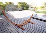 un hamac suspendu à un support en bois sur la terrasse
