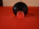 a bottle of wine sitting on a red cloth