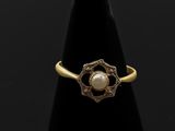 une bague en or avec une perle au centre