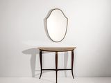 un miroir ovale posé sur une petite table, avec une autre petite table en dessous
