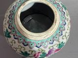 a vase with a lid sitting on a table next to a box